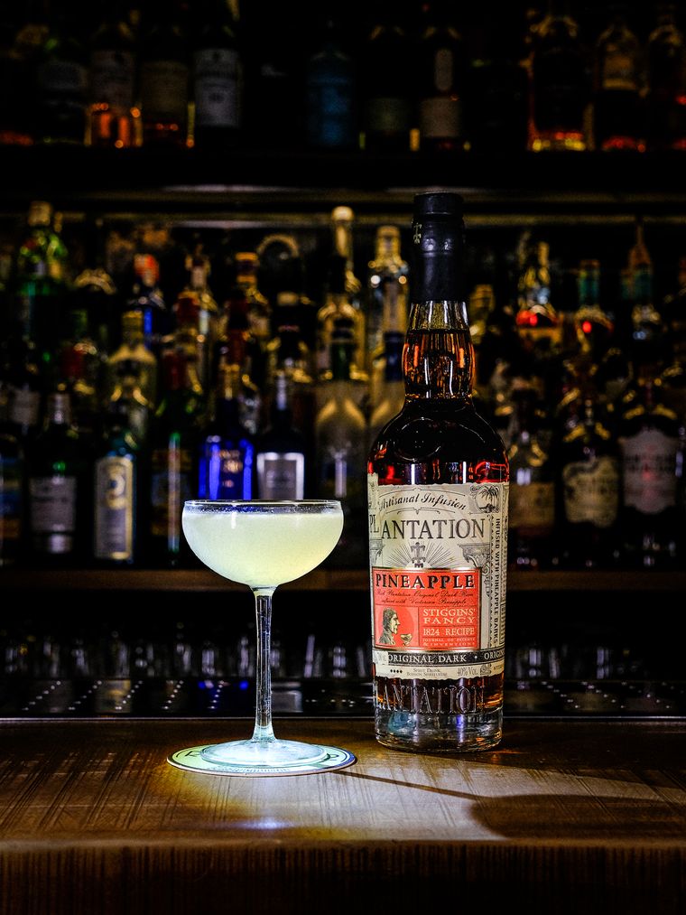 Daiquiri servido en copa junto a la botella de ron
