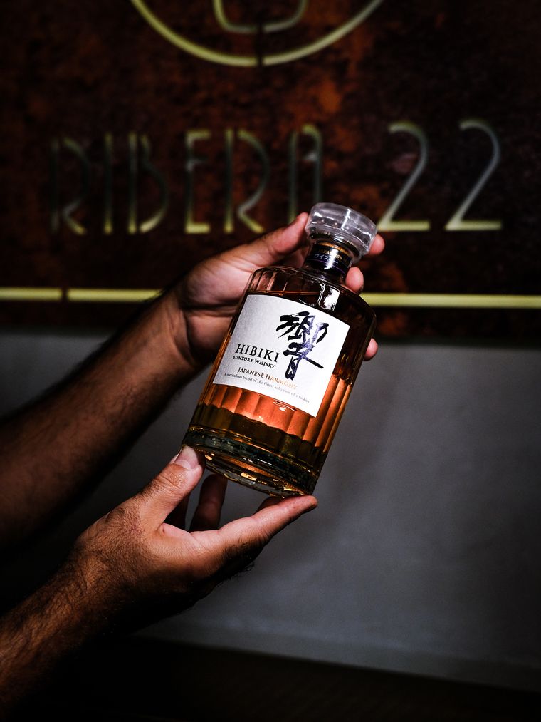 Botella de whisky japonés delante del rótulo de Ribera 22