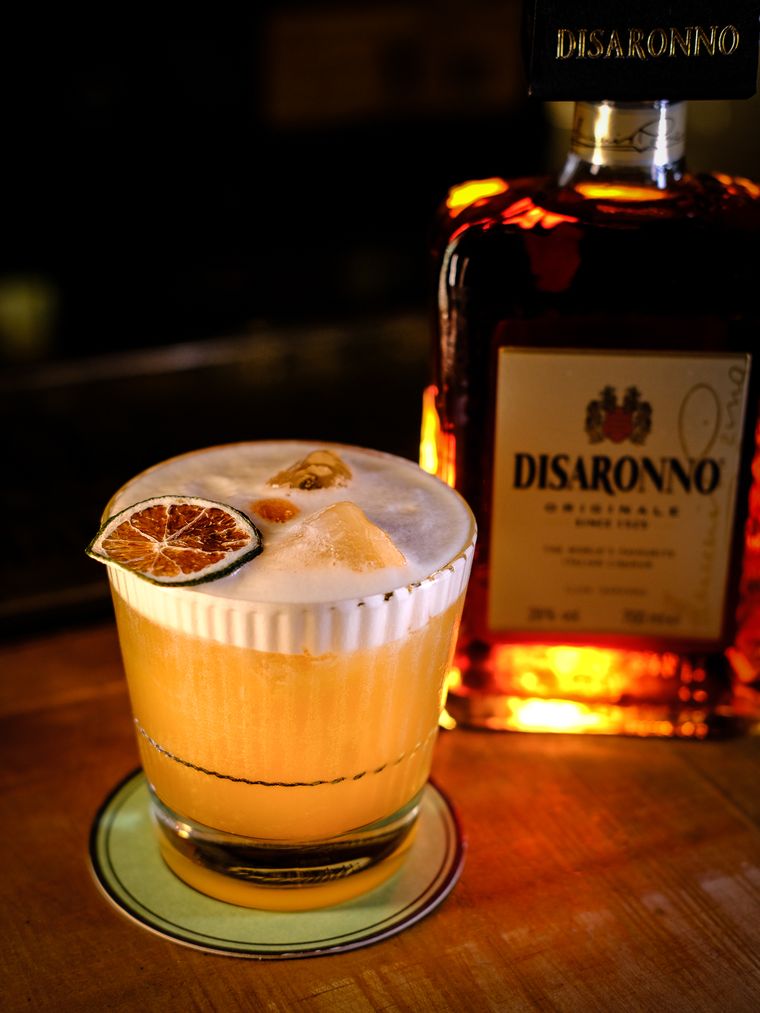 Cóctel sour con naranja deshidratada sobre la barra de Ribera22